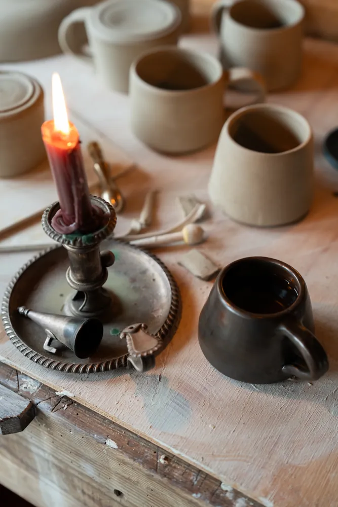 A candle glowing amongst Isa’s handmade pottery