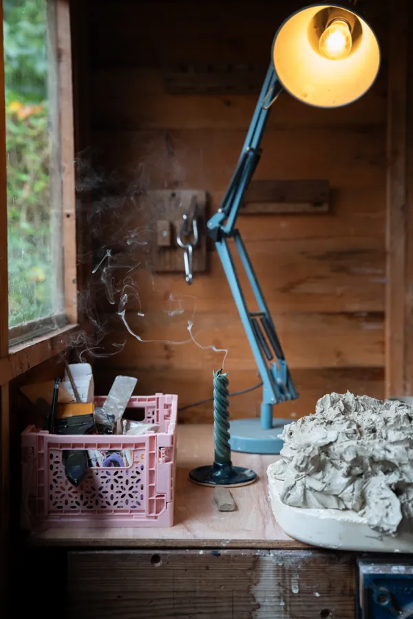 Tools, clay and a lamp in the garden pottery studio